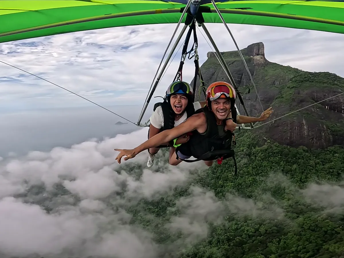 Voo duplo de asa-delta acima das nuvens, com a Pedra da Gávea ao fundo